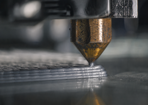 Bico de impressora 3D em ação, a depositar camadas de filamento